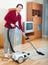 Happy mature woman cleaning with vacuum cleaner