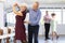 Happy mature woman enjoying impassioned merengue with male partner in dance class. Social dancing concept