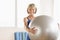 Happy Mature Woman Holding Yoga Ball At Home