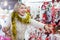 Happy mature woman in tinsel with Christmas toys at fair