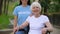 Happy mature woman in wheelchair and young volunteer looking camera, charity