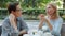 Happy mature women chatting in outdoor cafe relaxing at table enjoying company