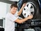 Happy Mechanic Fixing Hubcap To Car Tire