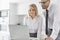 Happy mid adult business couple using laptop at kitchen counter