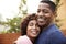 Happy middle aged African American  couple embracing smile to camera, close up