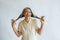 Happy middle aged Asian woman holds twisted hoary hair on light grey background