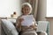 Happy middle aged elderly woman reading paper document.