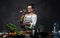 Happy middle-aged female chef tossing fresh fruit in the air from a blender in kitchen