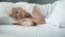Happy middle-aged female sleeping in bed on orthopedic mattress, health