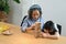 Happy middle aged grandma and little grandchild playing wood block stacking board game together in living room. Multi