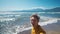 happy middle aged greyhead man walks along beautiful beach Iztuzu and takes selfie at sea coast with waves enjoying