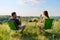 Happy middle-aged married couple having rest outdoors, in meadow, back view.