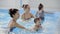 Happy middle-aged mother swimming with cute adorable baby in swimming pool. Smiling mom and little child, newborn girl