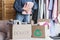Happy middle aged woman holding cardboard recycling box with clothes