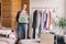 Happy middle aged woman holding cardboard recycling box with clothes