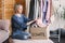 Happy middle aged woman holding cardboard recycling box with clothes