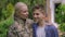 Happy military woman and teenage boy standing outdoors smiling looking at camera. Portrait of positive Caucasian mother