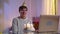 Happy millennial birthday man waving and talking in video chat on laptop showing thumbs up. Candles burning on cake