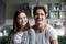 Happy millennial couple looking at camera in kitchen, headshot p