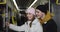 Happy millennial couple talking while going on public transport. Young man and girl smiling and talking while looking at