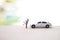 Happy miniature couple with new car over blurred background