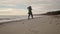 Happy mixed ethnic woman running away on sandy sea beach to background bokeh. Playful smiling asian female airy hair