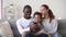 Happy mixed ethnicity family dad son and mom using phone