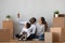 Happy mixed ethnicity family discuss new home sit with boxes