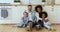 Happy mixed race family sitting on kitchen floor at home