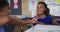 Happy mixed race female teacher showing schoolgirl manual excersises with hands