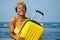 Happy mixed race hispanic brazil woman in yellow swimming suit bra and demin shorts having fun at beach with ribbon