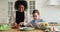 Happy mixed-race mom and child daughter cooking looking at camera