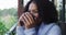 Happy mixed race woman enjoying drinking coffee standing on balcony in countryside