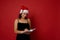 Happy mixed race woman wearing Santa hat, smiles writing on notepad plans and list to do for the new year. Christmas and New year