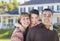 Happy Mixed Race Young Family in Front of House