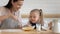 Happy mom and daughter cooking pancakes together