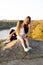 Happy mom and daughter relaxing on rocks in nature against the backdrop of the river. Happy Motherhood, Mother& x27;s Day