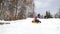 Happy mom and daughter sledding in winter in snow and playing snowballs. Mother and child laugh and rejoice glide on an