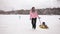 Happy mom and daughter sledding in winter in snow and playing snowballs. mother and child laugh and rejoice glide on an