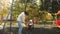 Happy mom rolls a small child in flight on a swing in the park. A mother with her daughter is walking on the weekend