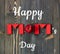 Happy mom`s day postcard on the background of Mom word from red toy bricks and an apple flat on dark textured wood