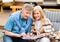 Happy moments. Senior couple admiring photos in family album, remembering their youth at campground