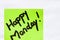 Happy Monday handwriting text close up isolated on green paper with copy space. Writing text on memo post reminder