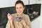 Happy mornings. Gorgeous young woman eating cereals with milk, standing in kitchen with breakfast bowl, enjoying start