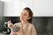 Happy mornings. Gorgeous young woman eating cereals with milk, standing in kitchen with breakfast bowl, enjoying start