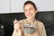 Happy mornings. Gorgeous young woman eating cereals with milk, standing in kitchen with breakfast bowl, enjoying start