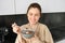 Happy mornings. Gorgeous young woman eating cereals with milk, standing in kitchen with breakfast bowl, enjoying start