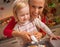 Happy mother and baby decorating homemade christmas cookies