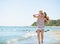 Happy mother with baby running along sea shore