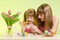 Happy mother and child daughter prepare to Easter holiday with brush coloring eggs